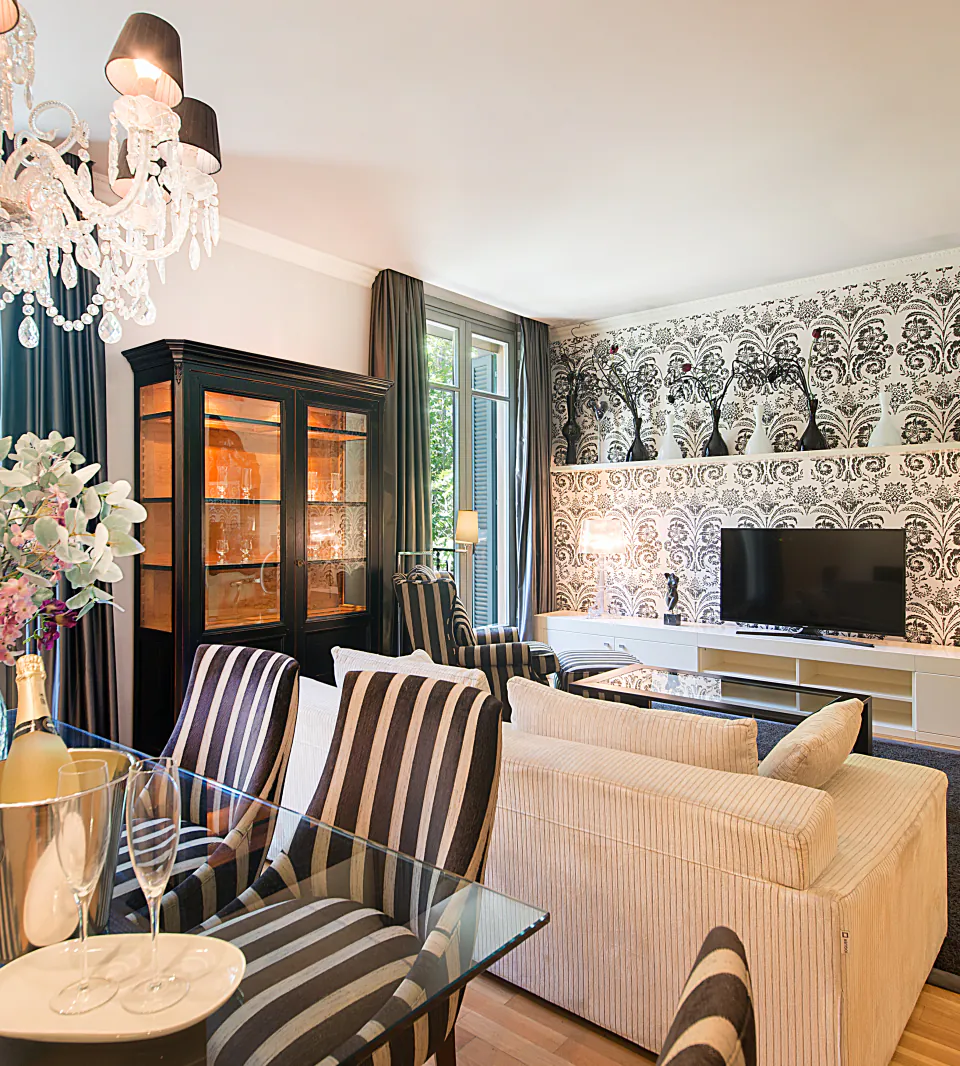 Sala d’estar de disseny de Casa Verdú amb seients de ratlles i una paret decorativa estampada