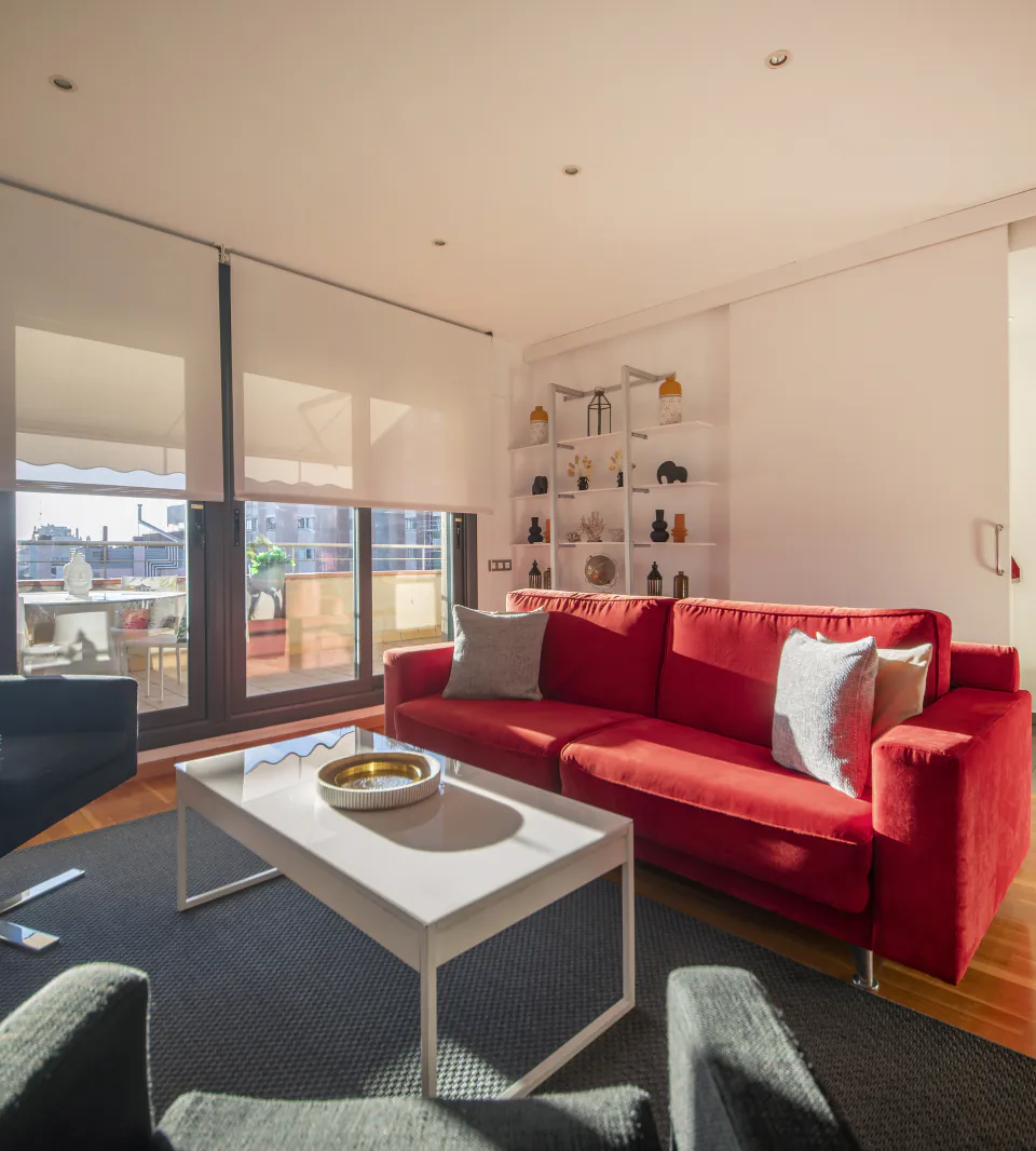 Sala d’estar de Suite Divina amb un sofà vermell oberta a la terrassa privada