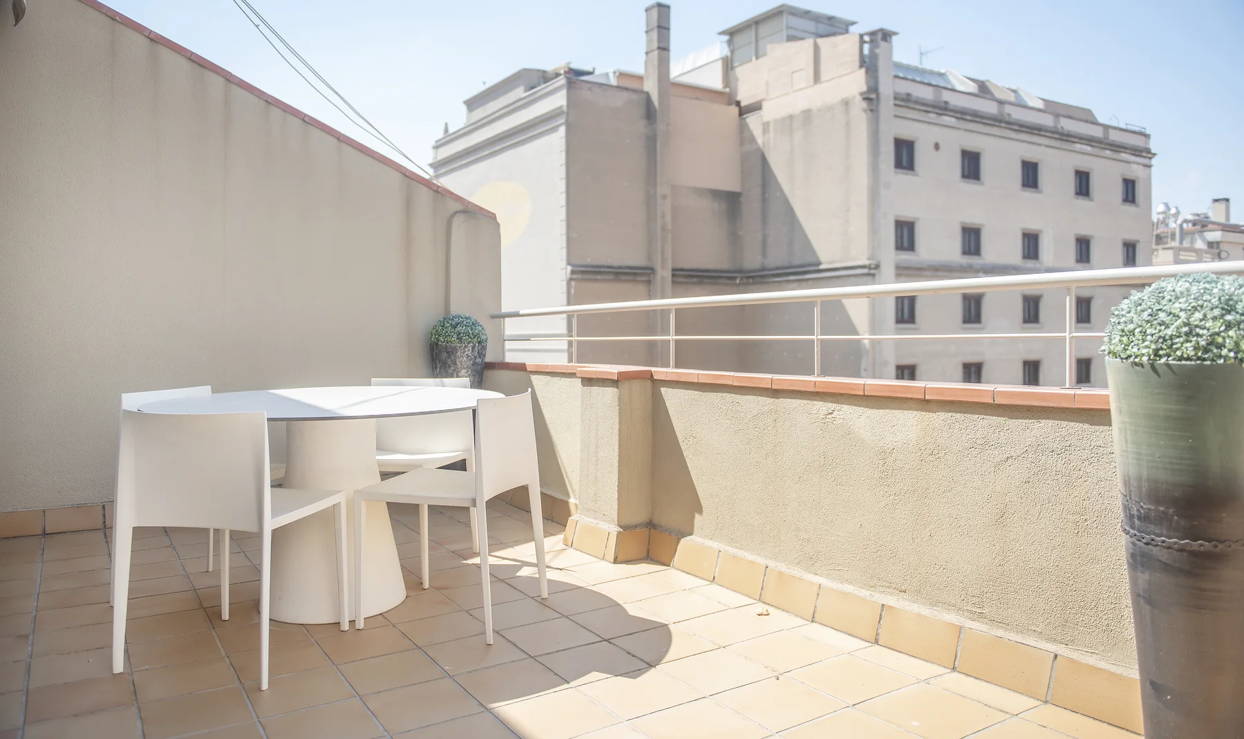 Suit Divina taula de terrassa al costat de la paret del balcó