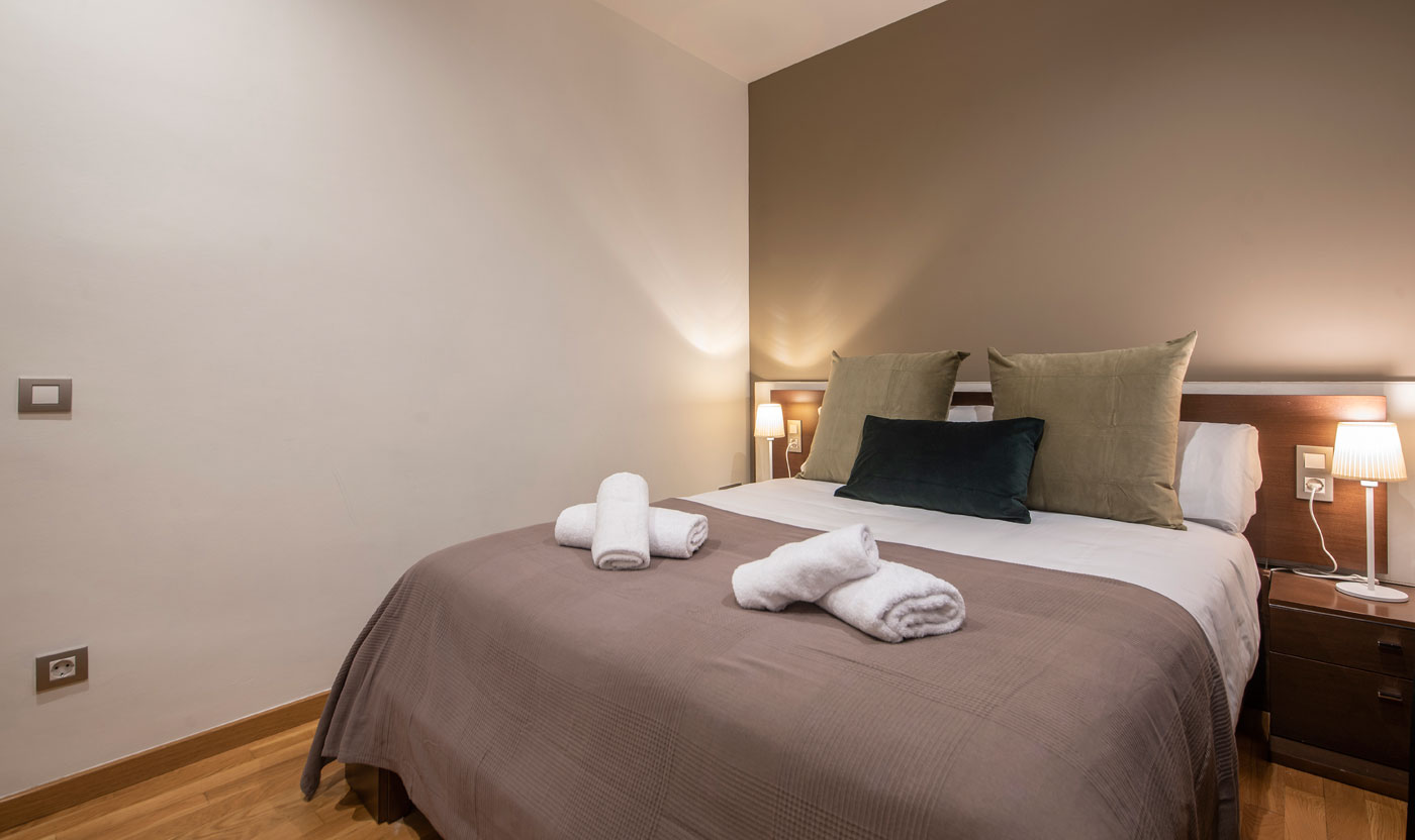 Cama Queen con mesitas de noche en Suite Sagrada