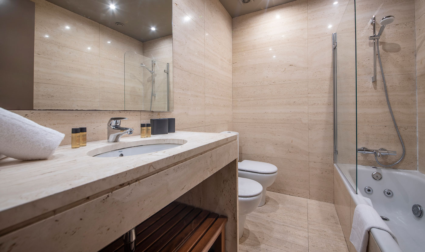 Baño en suite con bañera y ducha en Suite Sagrada
