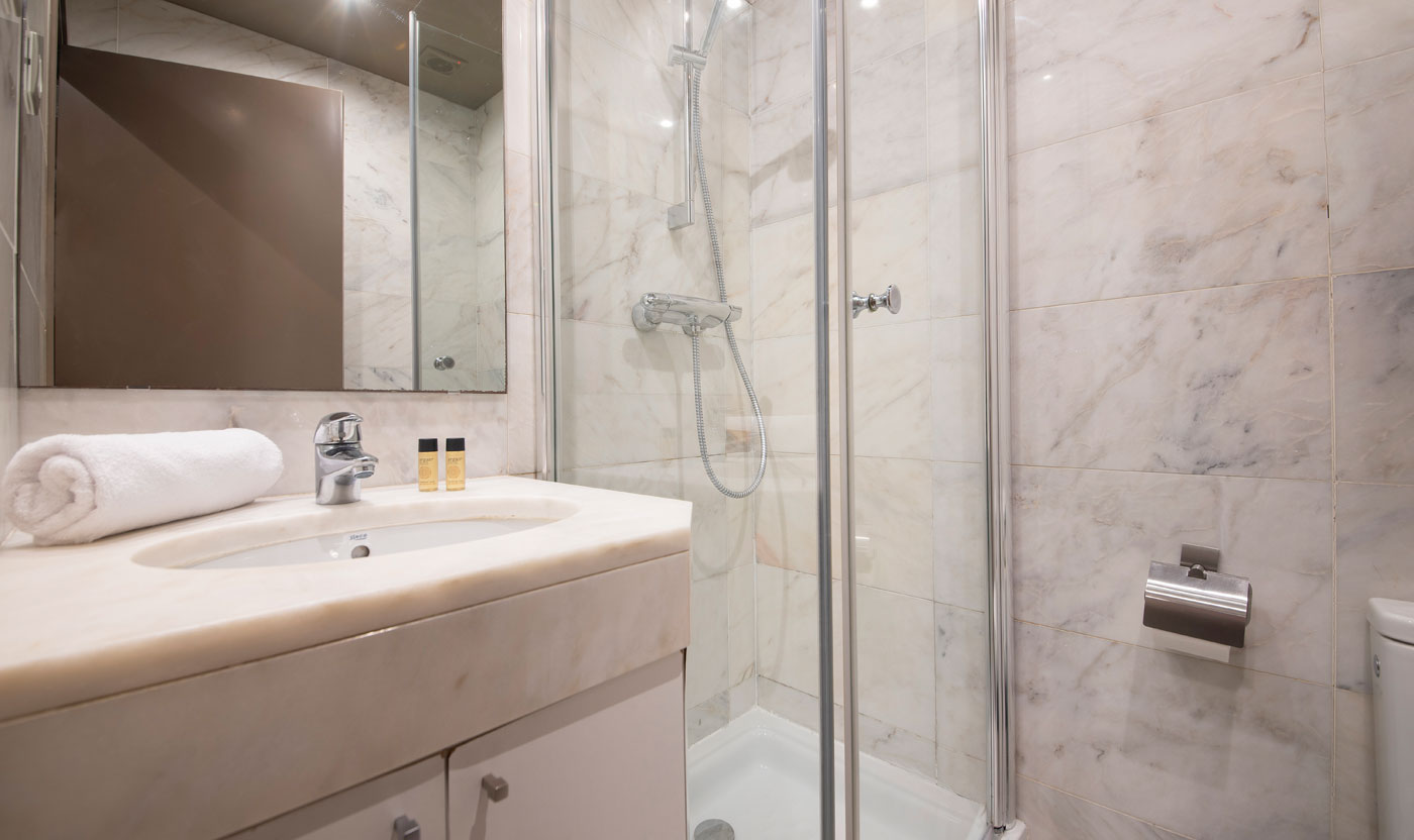 Baño del pasillo de Suite Sagrada con ducha a ras de suelo y mampara de cristal