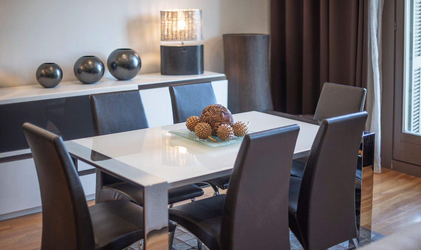 Mesa de comedor y ventanas de balcón en Suite Sagrada