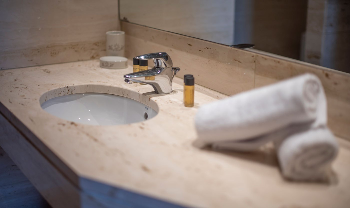 Lavabo de pedra i tovalloles doblades al bany principal Suite Soléa