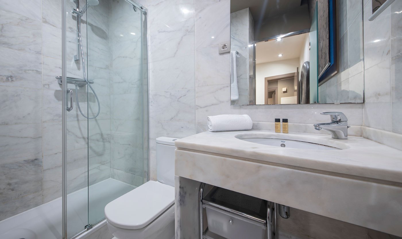 Bany de marbre en suite amb dutxa de vidre a Suite Soléa